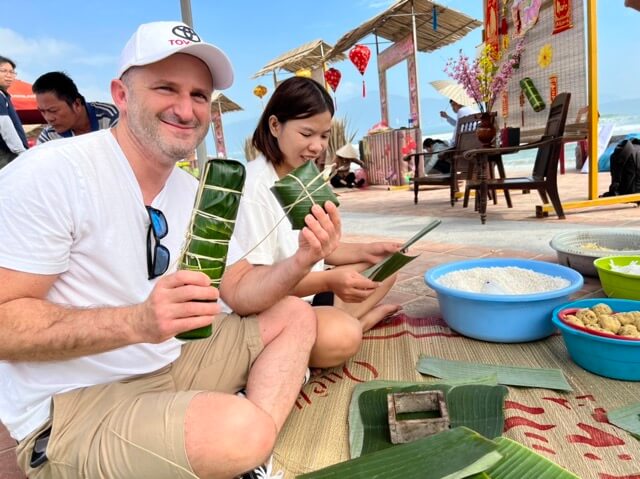 Tourists are wrapping banh tet during springtime for Vietnamese Lunar New Year.